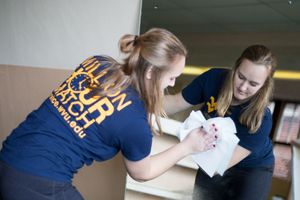 A WVU Tech students cleans a mirror during an MLK Day service project for the Women's Resource Center in Beckley