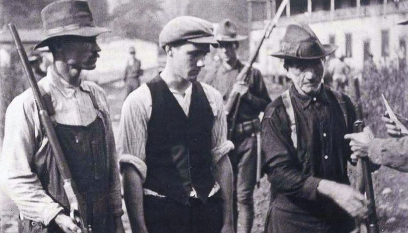 A black and white photograph of three miners