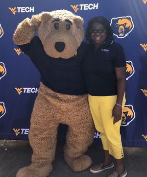 Tammy Saunders poses for a photo with Monty, the Golden Bear mascot.