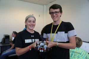 Two students from Camp STEM show off their LEGO Mindstorms robot.