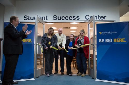 Students and staff cut a ribbon during the grand opening ceremony of the Student Success Center on the Beckley campus.