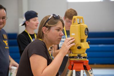 A camp STEM student uses a total station during the civil engineering class.