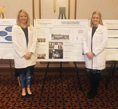 WVU School of Nursing faculty members Hillary Parcell MSN, RN and Kelly Morton MSN, RN stand in front of their presentation poster at the WV Nurses Association Policy Summit.