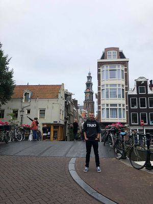 Cody Walker stands for a photo in the city of Amsterdam wearing a TRIO shirt.