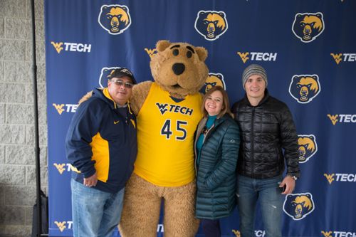 A family poses with Monty at Family Weekend