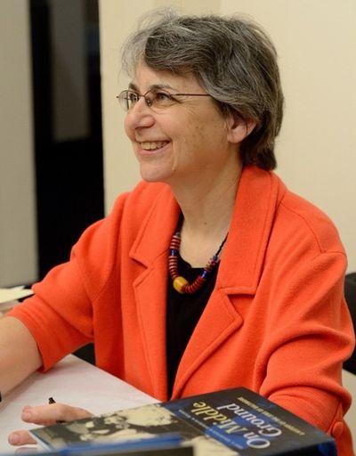A headshot of Dr. Deborah Weiner. She is wearing an orange blazer and is smiling. 
